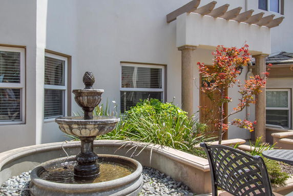 Front view of a house with a decorative stone fountain and columns.
