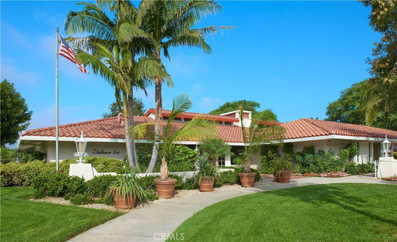 Front view of a clubhouse with a tiled roof and flagpole.