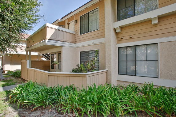 Front view of a two-story residential building with balconies and large windows.