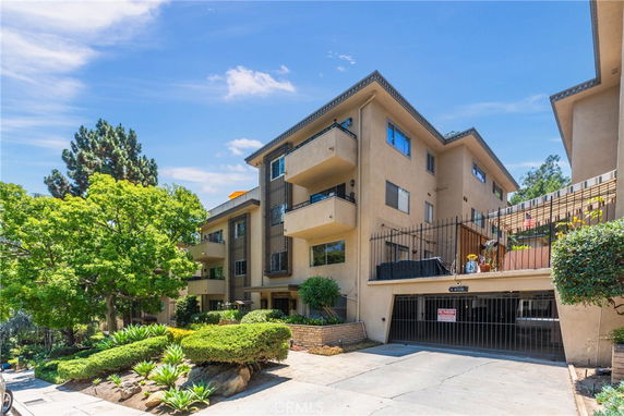 Front view of a multi-story apartment building with balconies.