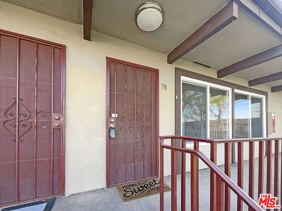 Front view of a building entrance with two doors and a doormat.