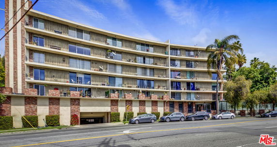 Front view of a multi-story residential building with outdoor balconies.