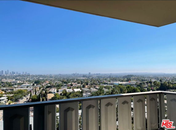 Wide angle view from a balcony overlooking the city with a clear sky.