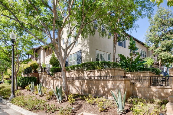 Front view of a two-story house with a garden and elevated patio.