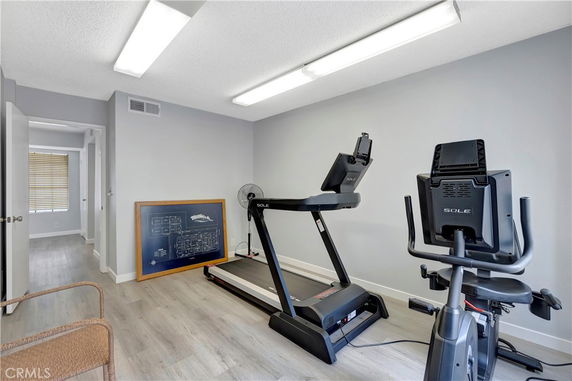 Indoor space with exercise equipment including a treadmill and exercise bike.