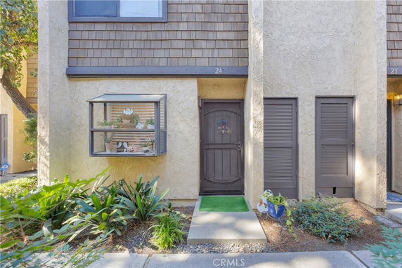 Front view of a house with a small garden and a window box.