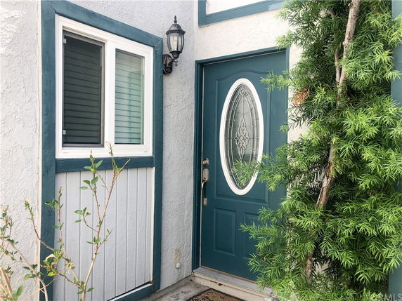 Front view of a house entrance with a blue door and window.