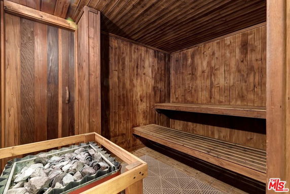 Interior view of a wooden sauna room with benches and a heater.