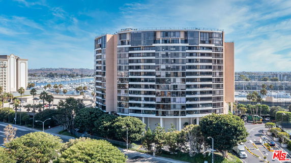Front view of a large multi-story residential building with a curved facade.