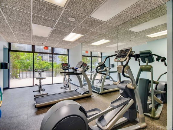 Interior view of a gym with exercise equipment, including treadmills and elliptical machines.