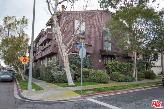 Front view of a multi-story residential building at a street corner.