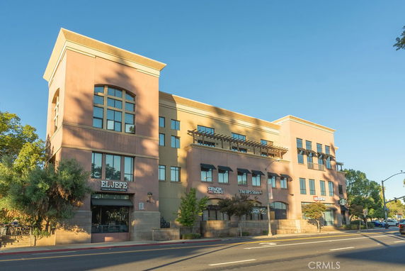 Front view of a multi-story commercial building with various businesses on the ground floor.
