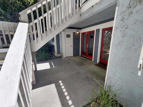 Front view of an entrance with red doors and an outdoor staircase.