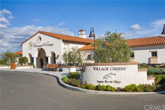 Front view of a single-story building with a restaurant and lounge, featuring a Spanish-style design with red-tiled roof.