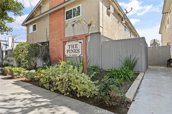 Front view of a two-story building with a sign that reads 'The Pines.'