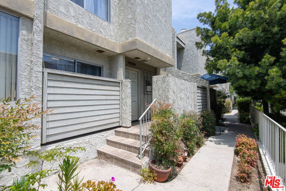 Front view of a two-story residential building with textured exterior walls.