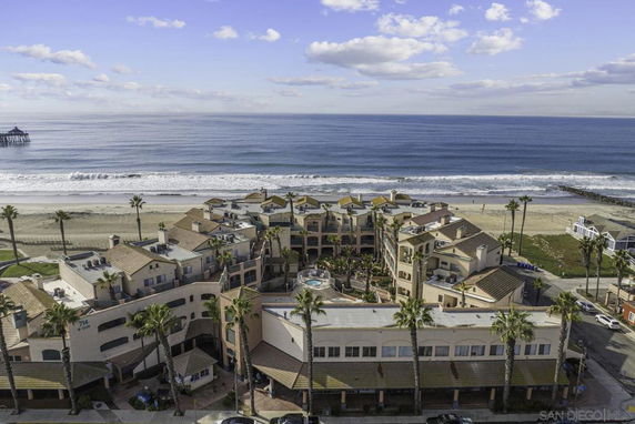 Aerial view of seaside buildings with ocean and beach in the background.
