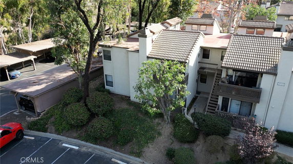 Elevated view of a multi-story residential building with a tiled roof and balconies.