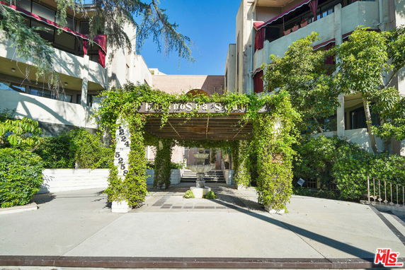 Front view of a multi-story building with vine-covered entrance.