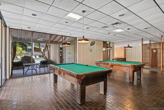 Room with pool tables and glass walls.