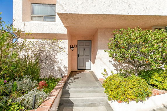 Front entrance of a house with a pathway and greenery.