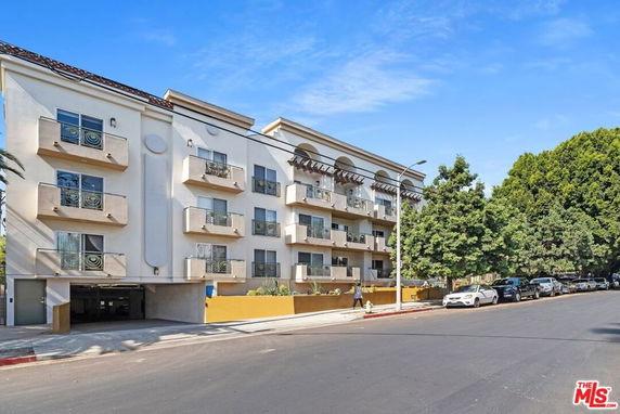 Front view of a multi-story apartment building with balconies.