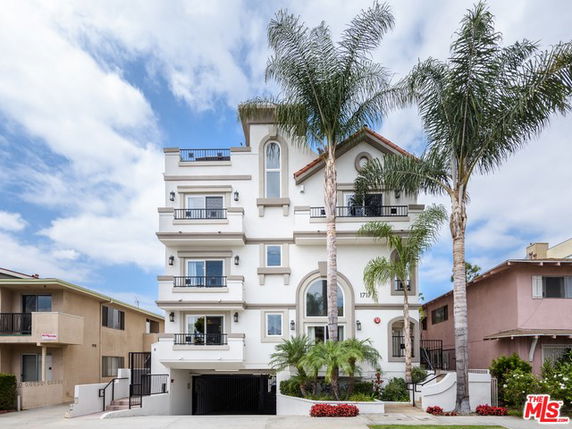 Front view of a multi-story residential building with balconies.