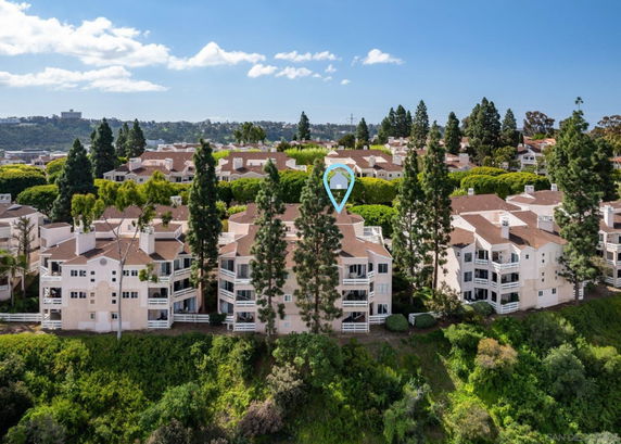 Aerial view of a residential area with multiple multi-story buildings surrounded by trees.