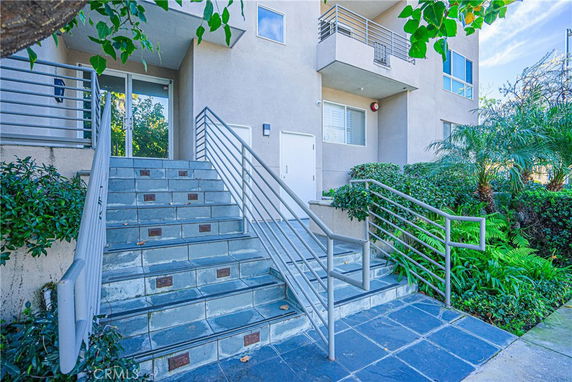 Front view of a modern multi-story building with a stairway entrance.