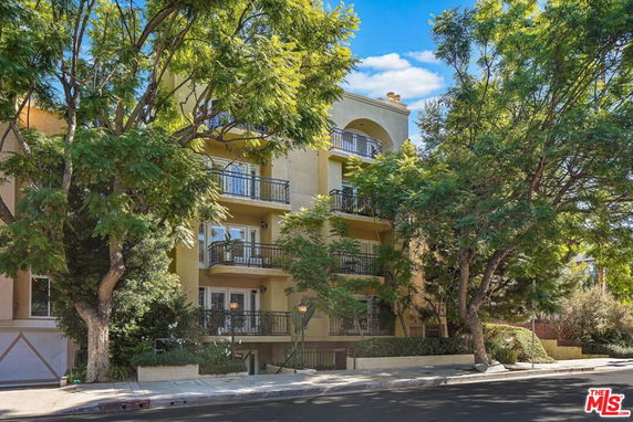 Front view of a multi-story residential building with multiple balconies.