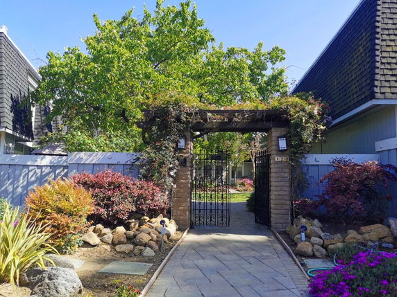 Front view of a house with a decorative gate and garden pathway.