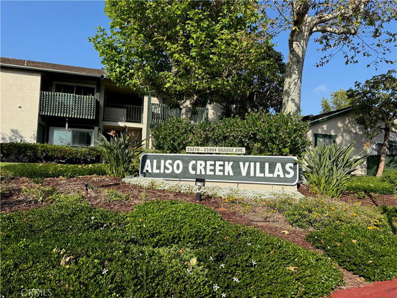 Front view of a residential building with a sign for Aliso Creek Villas.