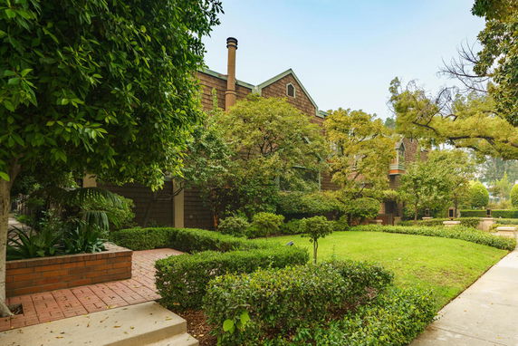 Front view of a multi-story building with brick pathways and greenery.