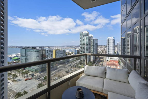 Panoramic view from a balcony looking at city skyscrapers and waterfront.