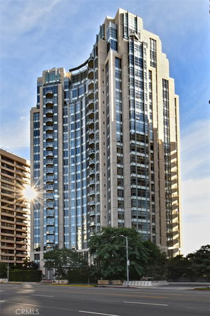 Front view of a high-rise building with glass and stone facade.