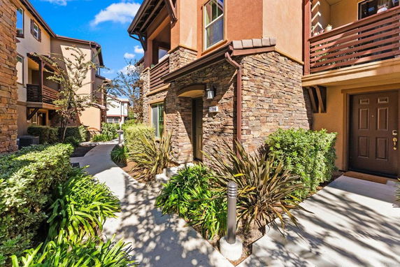 Front view of a multi-story building with stone and stucco exterior.