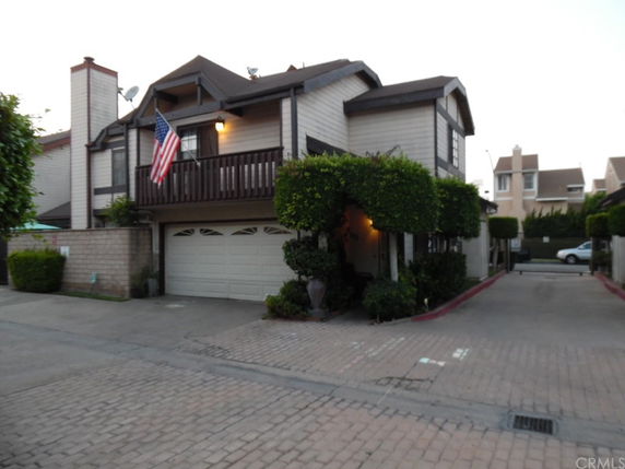 Front view of a two-story house with a balcony and double garage.