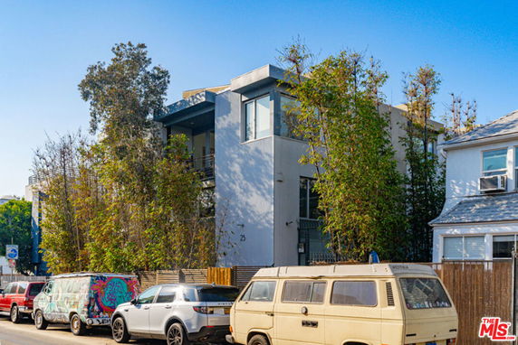 Front view of a modern two-story building with large windows and surrounding trees.