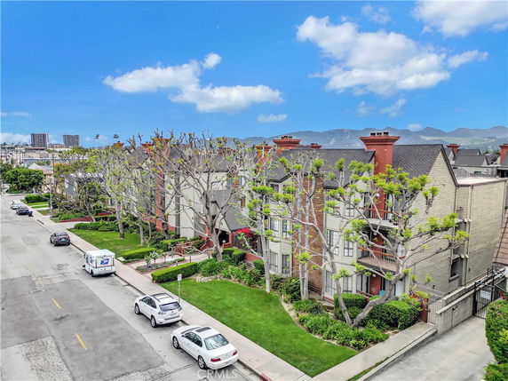 Front view of a multi-story residential building with chimneys and balconies.