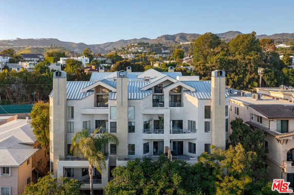Front view of a multi-story apartment building with angular roof design.