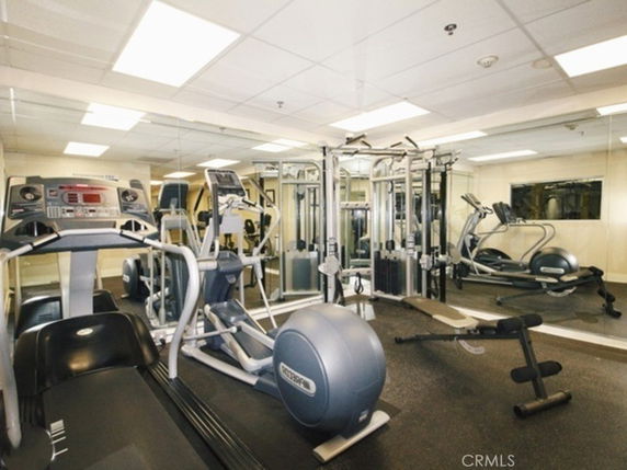 Interior view of a gym with various exercise equipment, including treadmills and strength machines.
