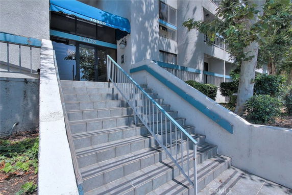 Entrance of a building with a staircase and blue awning.