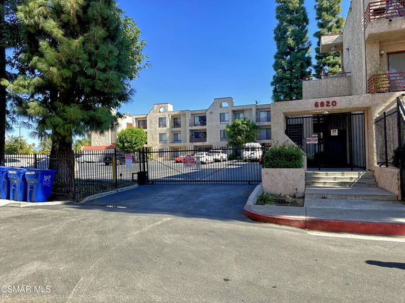 Front view of a multi-story residential building with gated entry.