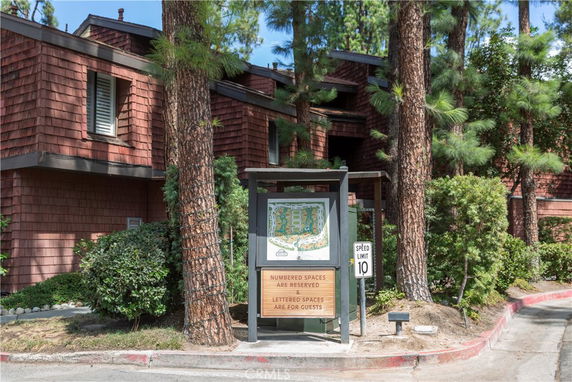 Front view of a multi-story building with wooden shingle exterior surrounded by trees.