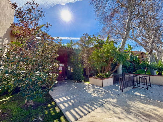 Front view of a building entrance with surrounding plants and trees.