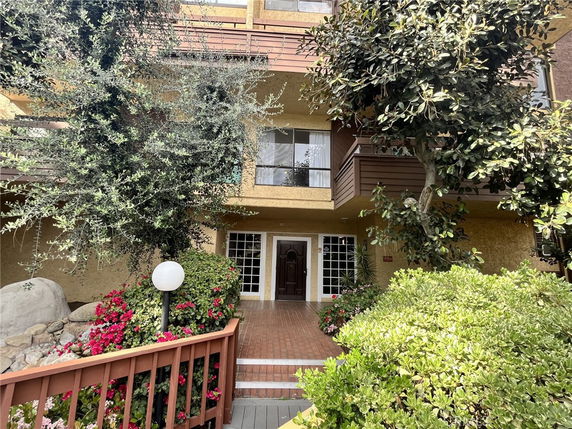 Front view of a multi-story building with a pathway leading to the entrance.