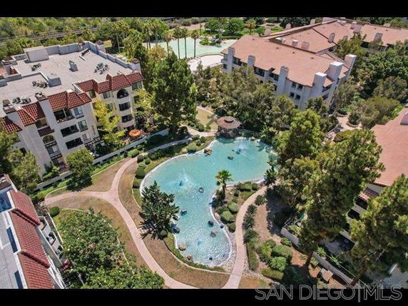 Aerial view of residential buildings with a landscaped garden and water feature.