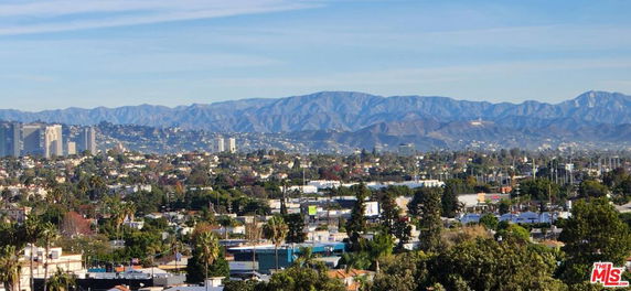 Panoramic view of a cityscape with mountains in the background.