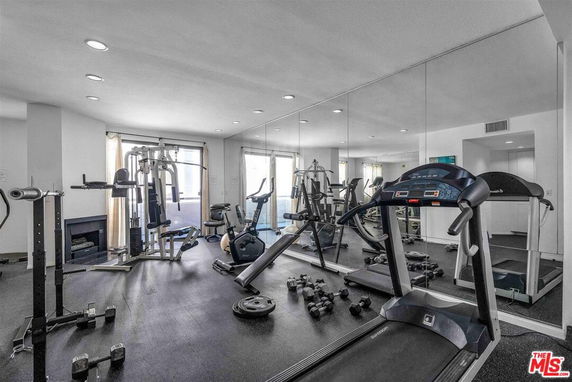 Indoor gym with treadmills, exercise bikes, and weightlifting equipment.