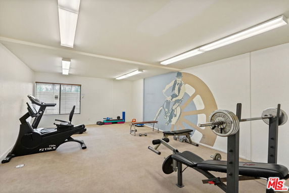 Indoor gym area with exercise equipment and fitness mural.